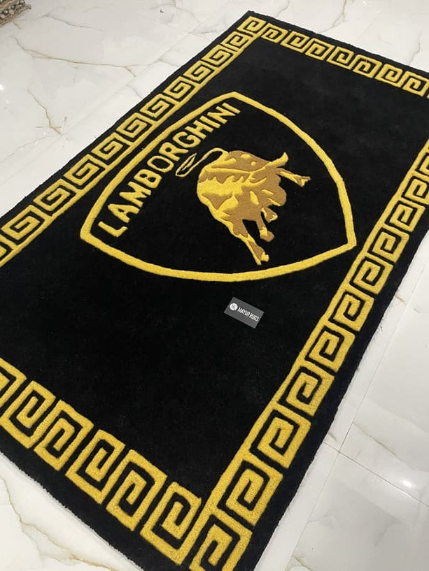 Black rug with gold border and logo on a white tiled floor