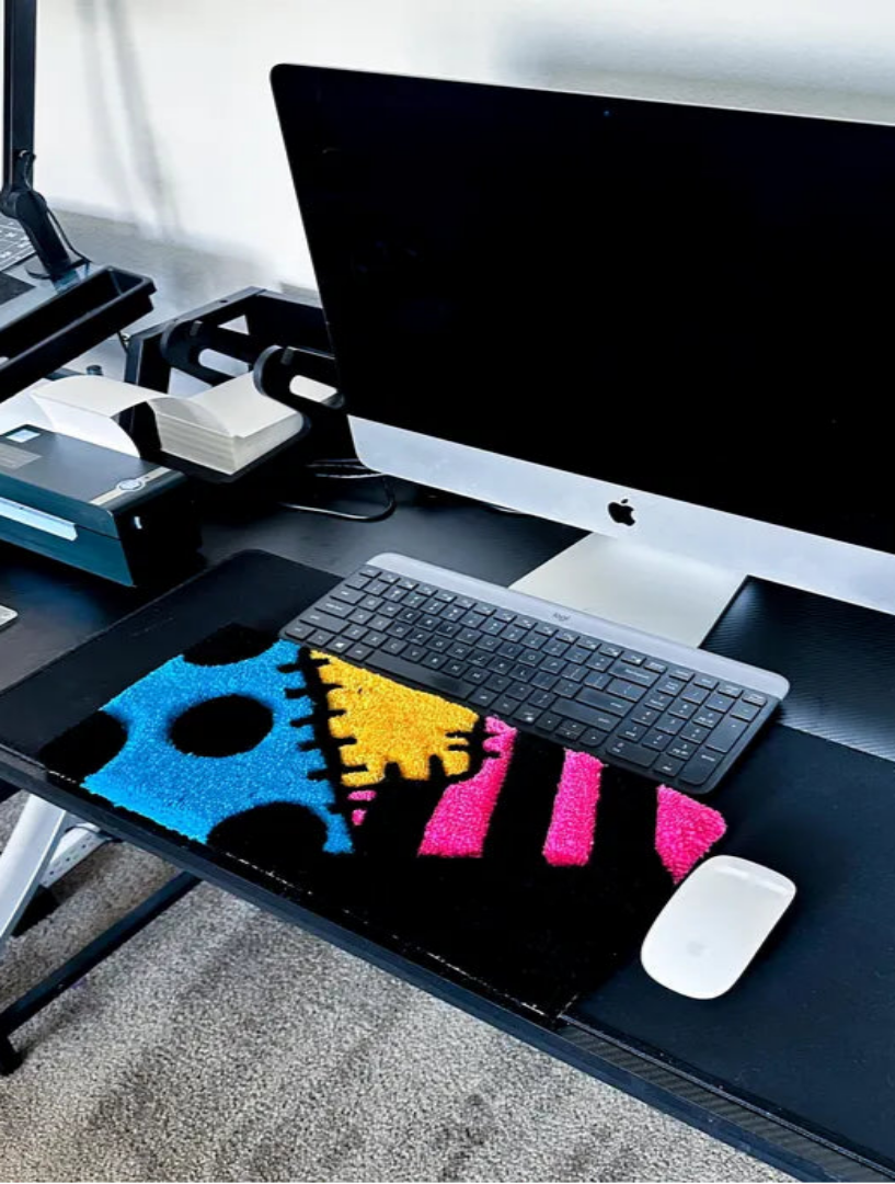 Modern office desk setup with a computer monitor, keyboard, and mouse on a black desk.