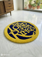 Round rug with 'The Lord of the Rings' design on a white floor.