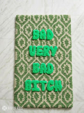Green and cream hand tufted loop and cut rug featuring raised Bad Very Bad Bitch typography by Mayur Rugs
