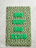 Green and cream hand tufted loop and cut rug featuring raised Bad Very Bad Bitch typography by Mayur Rugs