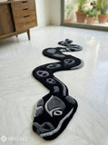 Black serpent hand tufted wool rug featuring snake shaped statement artwork by Mayur Rugs