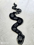 Black serpent hand tufted wool rug featuring snake shaped statement artwork by Mayur Rugs
