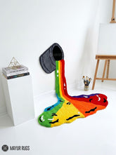 Rainbow paint spill hand tufted wool wall art rug featuring a colorful tipped paint bucket and flowing rainbow design by Mayur Rugs.