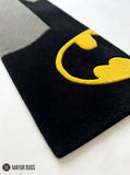Batman minimal hand-tufted rug handmade in India by Mayur Rugs featuring a sleek black silhouette with the iconic yellow bat emblem in a modern superhero-inspired design.