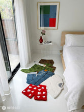 Dirty laundry hand-tufted custom wool rug featuring a colorful pile of clothes, shorts, socks, and garments in green, blue, white, beige, and red with raised 3D detailing by Mayur Rugs.