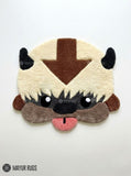 Appa inspired Avatar hand-tufted custom wool rug featuring the flying bison character with cream fur, dark horns, brown forehead arrow, expressive eyes, and pink tongue by Mayur Rugs.