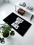 Kiss My Airs inspired hand-tufted wool rug featuring bold white typography and a swoosh-style graphic on a red background for sneakerhead and streetwear décor by Mayur Rugs.