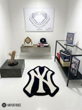 New York Yankees inspired hand-tufted custom wool rug featuring a cream interlocking NY baseball logo on a black background by Mayur Rugs.