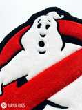 Ghostbusters inspired hand-tufted custom wool rug featuring a white ghost over a red circle with black background, raised 3D details, and a custom circular silhouette by Mayur Rugs.