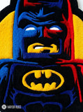 LEGO Batman inspired 3D hand-tufted custom wool rug featuring a black, blue, red, and yellow superhero character design with pointed bat ears, cape details, and a raised bat emblem by Mayur Rugs.