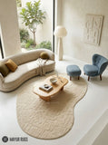 Ivory organic loop and cut hand-tufted wool area rug featuring raised abstract textured patterns and an irregular rounded shape for modern neutral interiors by Mayur Rugs.