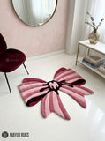 Pink ribbon bow 3D hand-tufted custom wool rug featuring layered blush, rose, dusty pink, and burgundy ribbon shapes with a sculpted center knot for coquette and feminine décor by Mayur Rugs.