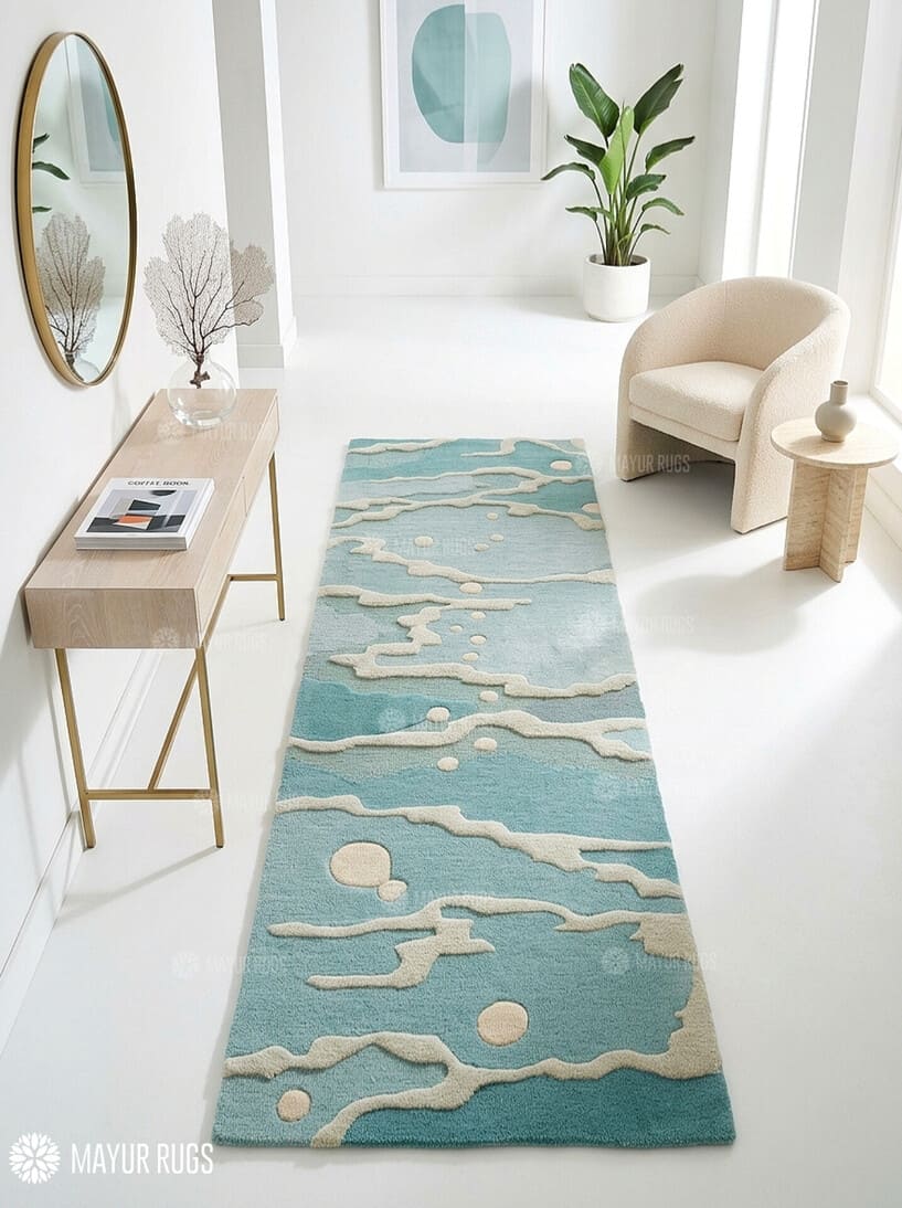 Coastal Tide abstract hand-tufted wool runner rug featuring a muted blue and teal base with raised ivory flowing wave patterns and scattered circular accents for modern coastal interiors by Mayur Rugs.