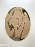Oval abstract rug with a sand-beige background and flowing taupe, brown, olive green, and black organic shapes by Mayur Rugs.