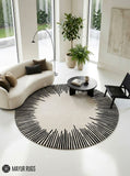 Round ivory area rug with radiating black sunburst lines in varied lengths, creating a bold minimalist monochrome design by Mayur Rugs.