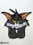 Tom inspired Tom & Jerry hand-tufted custom wool rug featuring a grey cartoon cat character with yellow eyes, white muzzle, pointed ears, oversized paws, and detailed 3D artwork by Mayur Rugs.