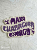 Patch with 'MAIN CHARACTER ENERGY' text on a textured surface, brand 'MAYUR RUGS' visible.