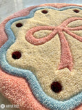 Blush bow cookie hand-tufted wool rug with pastel round design and soft aesthetic details, premium custom area rug by Mayur Rugs