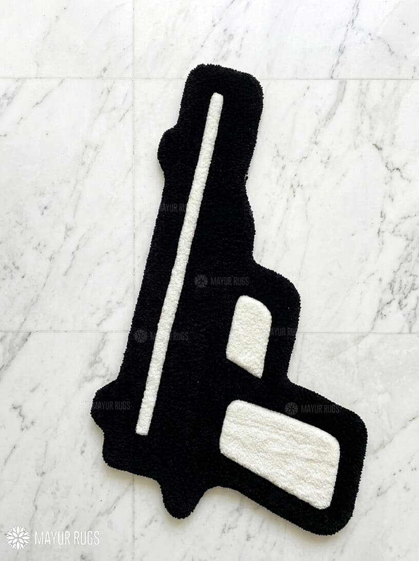 Black gun-shaped rug on a white textured surface