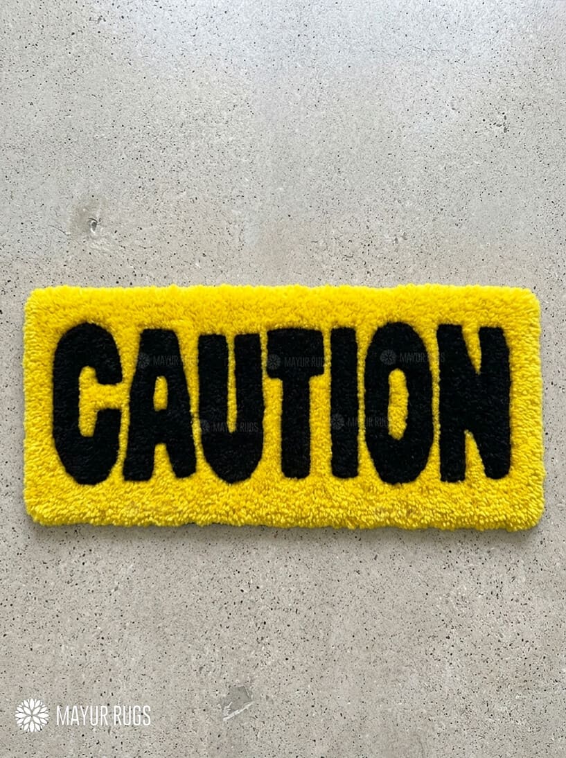 Caution typography hand-tufted wool rug with yellow and black industrial statement design by Mayur Rugs