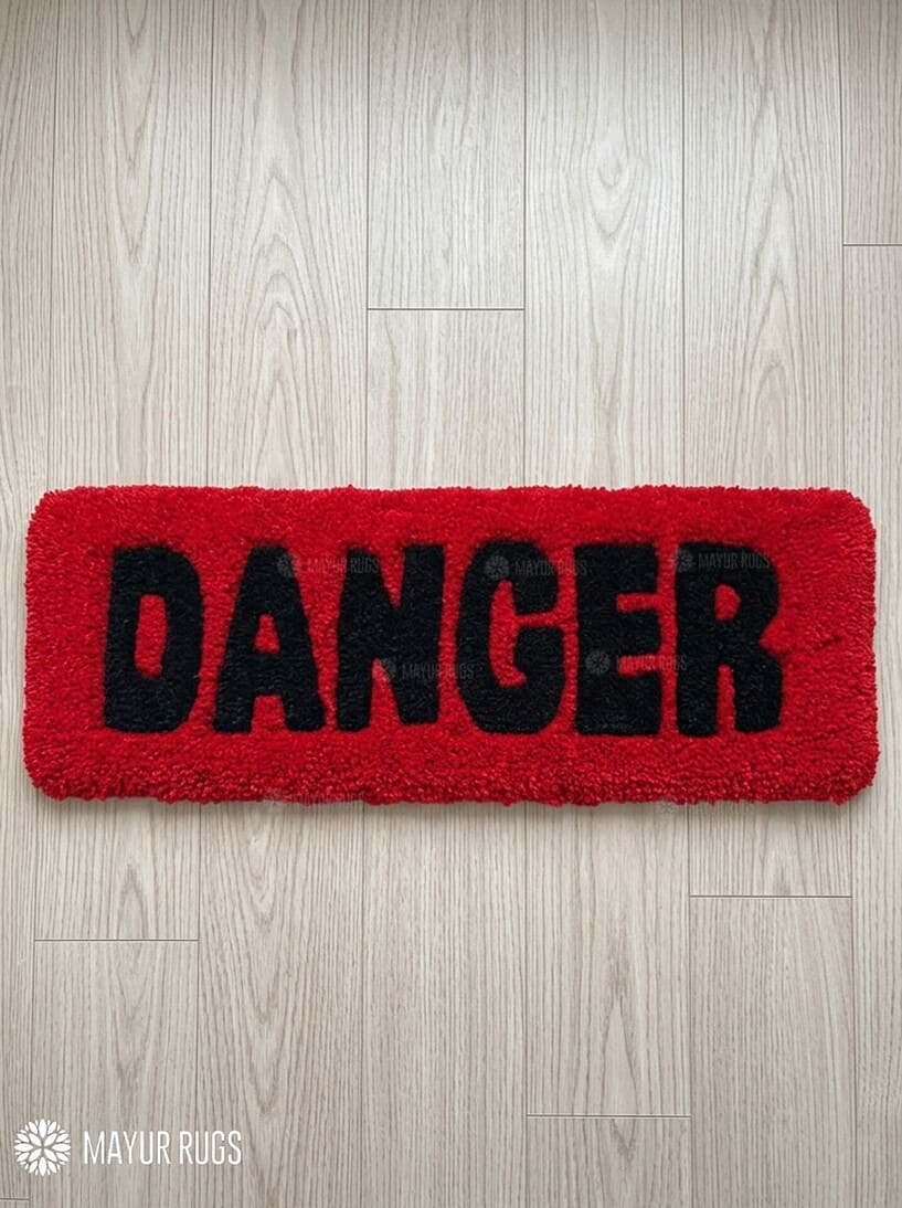 Danger typography hand-tufted wool rug with bold red and black statement design by Mayur Rugs