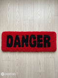 Danger typography hand-tufted wool rug with bold red and black statement design by Mayur Rugs