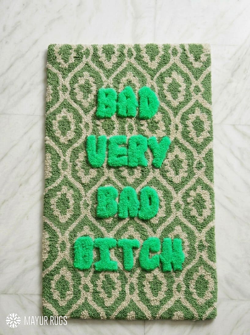 Green and cream hand tufted loop and cut rug featuring raised Bad Very Bad Bitch typography by Mayur Rugs