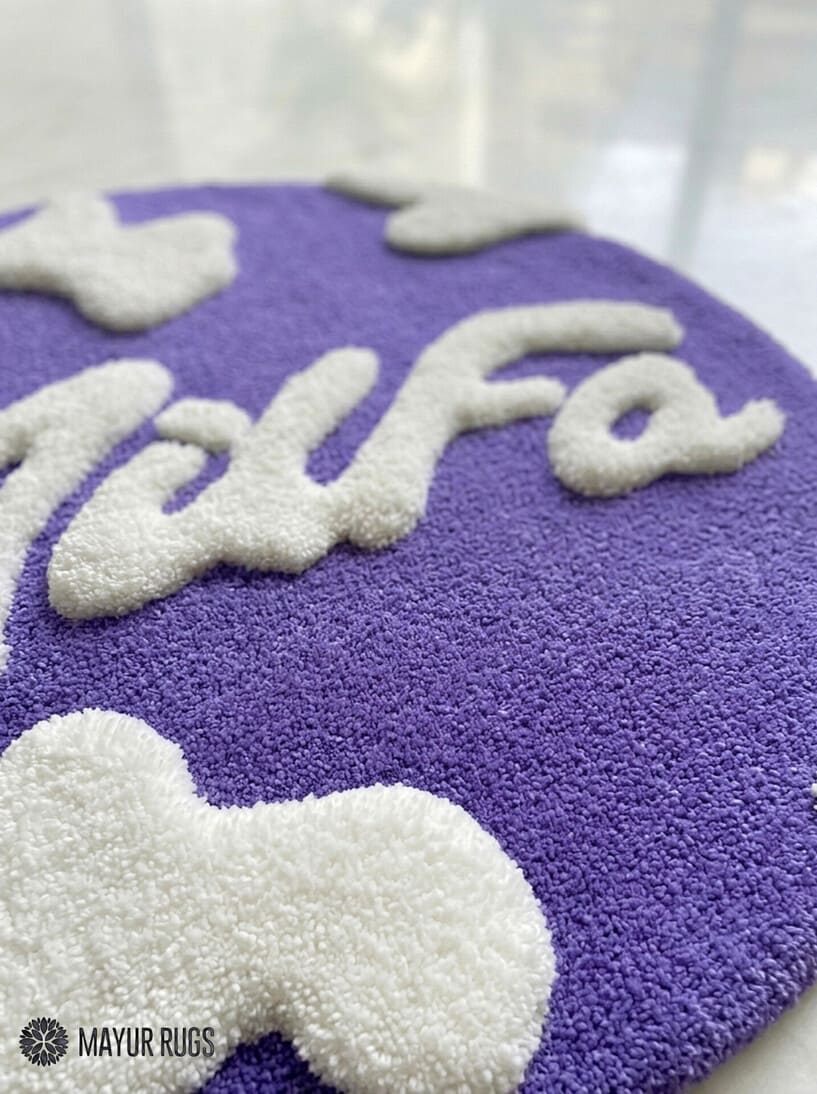 Purple round hand tufted wool MILFA logo rug with bold typography design by Mayur Rugs