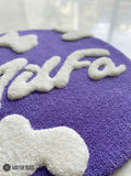 Purple round hand tufted wool MILFA logo rug with bold typography design by Mayur Rugs