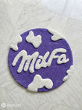 Purple round hand tufted wool MILFA logo rug with bold typography design by Mayur Rugs
