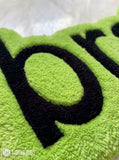 Lime green brat text hand-tufted wool rug featuring bold typography aesthetic by Mayur Rugs