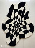 Black and white optical illusion hand-tufted wool rug featuring a distorted 3D geometric vortex pattern and modern op-art design by Mayur Rugs.