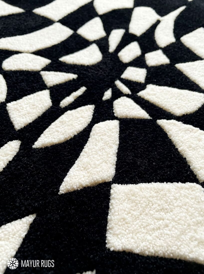 Black and white optical illusion hand-tufted wool rug featuring a distorted 3D geometric vortex pattern and modern op-art design by Mayur Rugs.