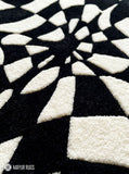 Black and white optical illusion hand-tufted wool rug featuring a distorted 3D geometric vortex pattern and modern op-art design by Mayur Rugs.