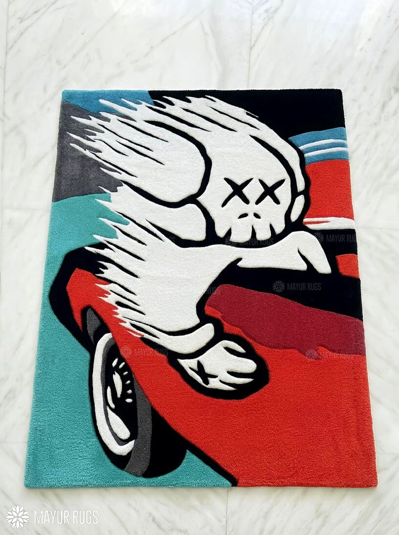 KAWS Racing Companion hand tufted wool rug featuring XX-eyed skull artwork leaning from a sports car by Mayur Rugs.