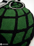 Grenade hand tufted custom wool rug featuring military tactical artwork with olive green grenade design by Mayur Rugs.