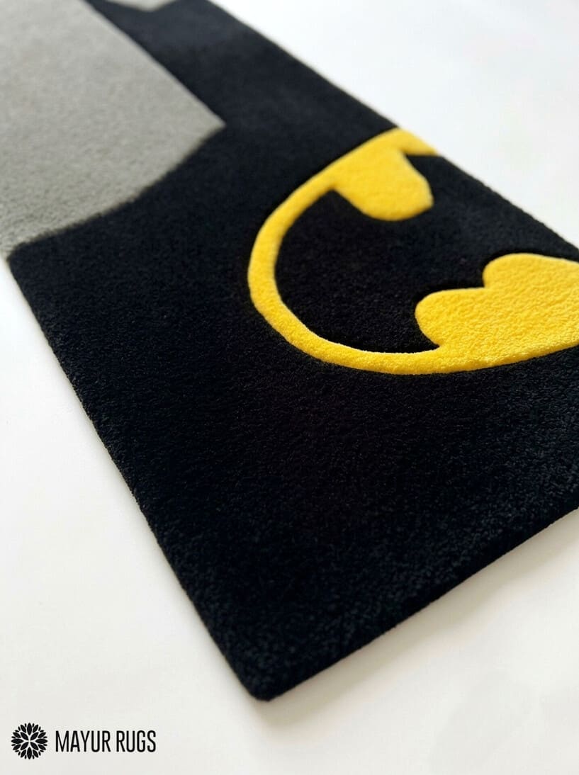 Batman minimal hand-tufted rug handmade in India by Mayur Rugs featuring a sleek black silhouette with the iconic yellow bat emblem in a modern superhero-inspired design.