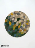 Abstract geometric round hand-tufted wool area rug featuring multicolor triangles and angular shapes in green, mustard, taupe, grey, blue, and cream by Mayur Rugs.