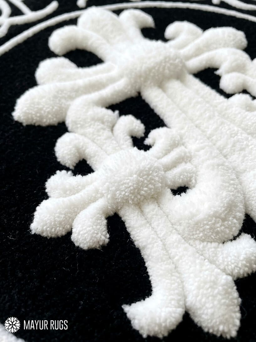 Close-up of a plush white tufted rug pattern on a black background, with the MAYUR RUGS logo in the bottom-left corner.