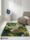 Abstract botanical camo hand-tufted wool area rug featuring layered green organic leaf and floral shapes in olive, moss, lime, beige, and charcoal by Mayur Rugs.