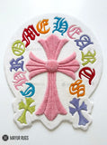 Chrome Hearts inspired colorful cross hand-tufted wool rug featuring a large pink gothic cross with multicolored cross motifs and ornate lettering by Mayur Rugs.