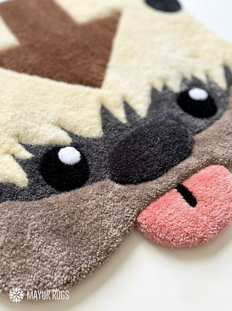 Appa inspired Avatar hand-tufted custom wool rug featuring the flying bison character with cream fur, dark horns, brown forehead arrow, expressive eyes, and pink tongue by Mayur Rugs.