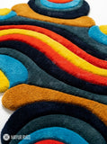 Wavy abstract hand-tufted 3D wool area rug featuring colorful sculptural curves and organic shapes in red, yellow, blue, orange, teal, charcoal, and navy by Mayur Rugs.