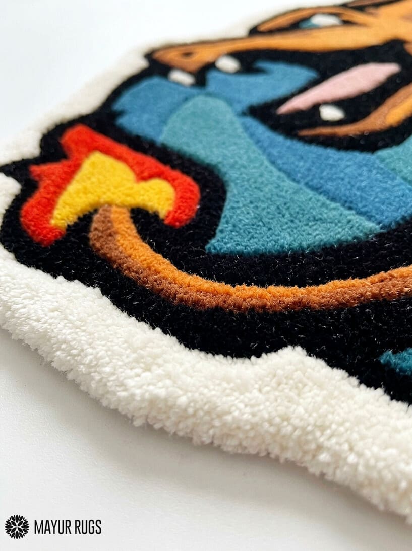 Charizard inspired Pokémon hand-tufted custom wool rug featuring an orange dragon-like character with blue wings, red flame details, sharp teeth, and sculpted 3D artwork by Mayur Rugs.