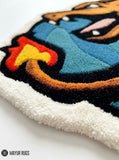Charizard inspired Pokémon hand-tufted custom wool rug featuring an orange dragon-like character with blue wings, red flame details, sharp teeth, and sculpted 3D artwork by Mayur Rugs.