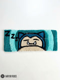 Snorlax inspired Pokémon hand-tufted keyboard rug featuring a sleepy blue and cream character design with pointed ears and expressive eyes for gaming desk and anime décor by Mayur Rugs.