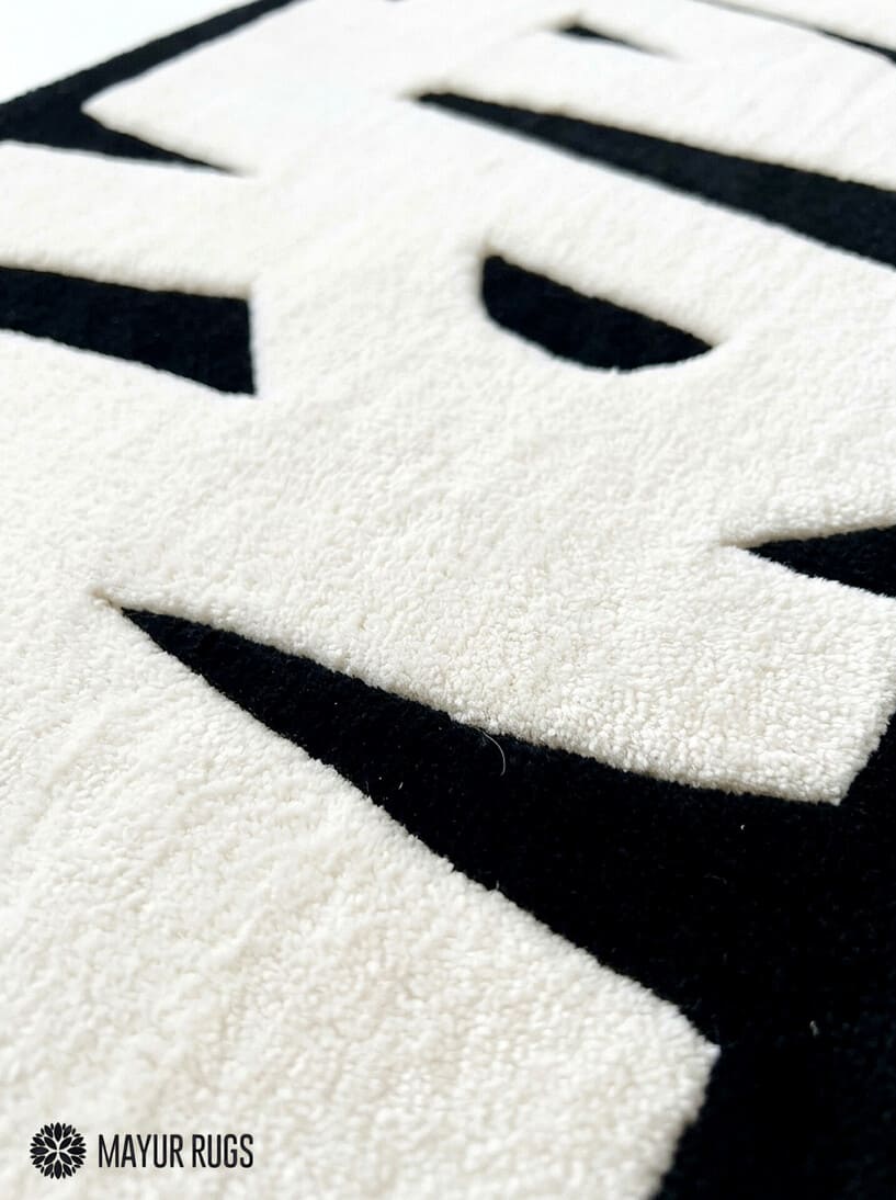 Marvel inspired hand-tufted wool area rug featuring oversized cream-white comic book lettering on a deep red background for superhero and pop-culture décor by Mayur Rugs.