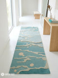 Coastal Tide abstract hand-tufted wool runner rug featuring a muted blue and teal base with raised ivory flowing wave patterns and scattered circular accents for modern coastal interiors by Mayur Rugs.