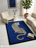 Rectangular hand-tufted leopard rug featuring a cream and black spotted leopard with turquoise eyes on a royal blue background and black border by Mayur Rugs.